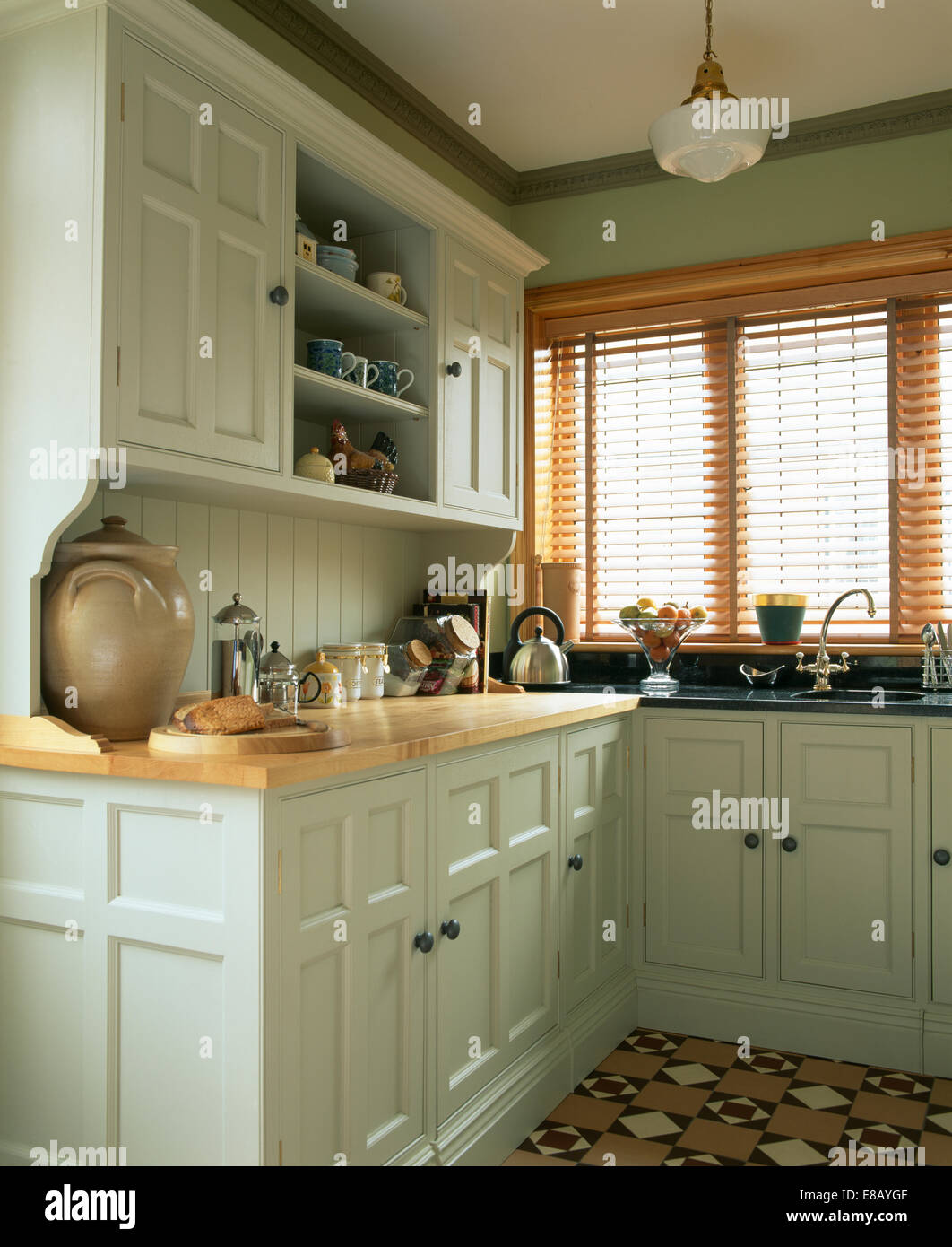 Lattenrost aus Holz Jalousie am Fenster in Küche im traditionellen Pastellgrün Küche in Farrow + Ball Farbe lackiert Stockfoto