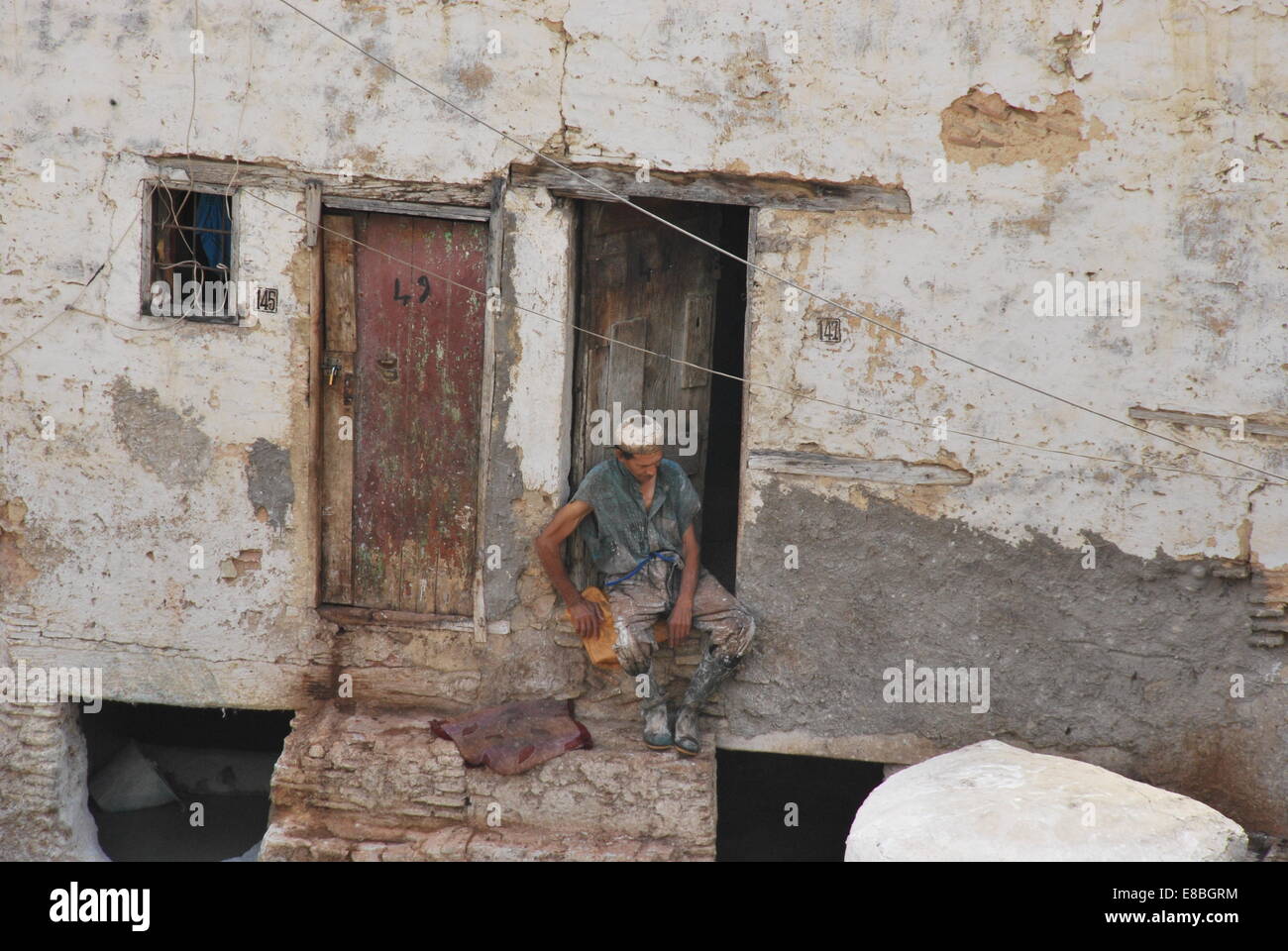 Marokko. Fez. Man ruht in der Tür.  Gerberei. Medina. Die Aushärtung erfolgt färben Skins. Der UNESCO. Natürliche Farbstoffe. touristische Attraktion. Stockfoto