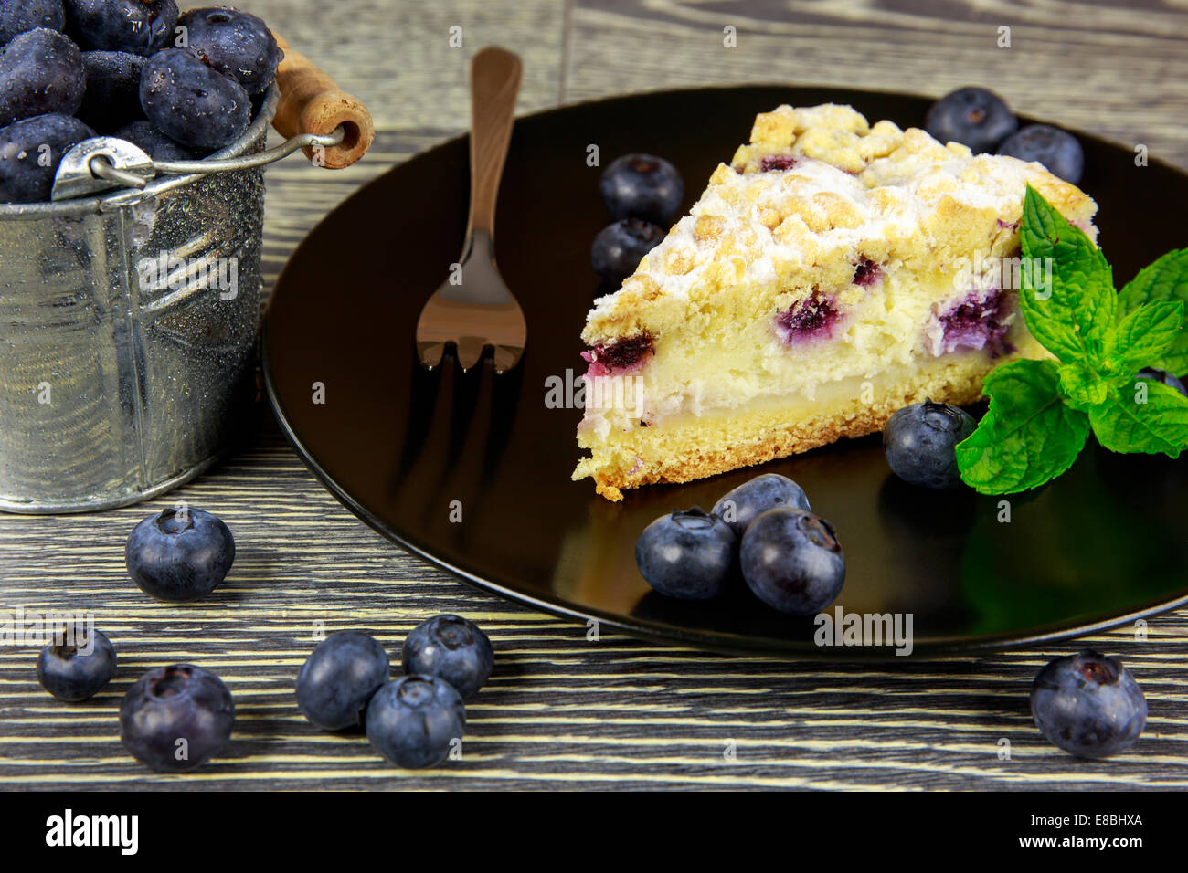Heidelbeer-Kuchen und frisches Obst angeordnet auf einem Holztisch Stockfoto