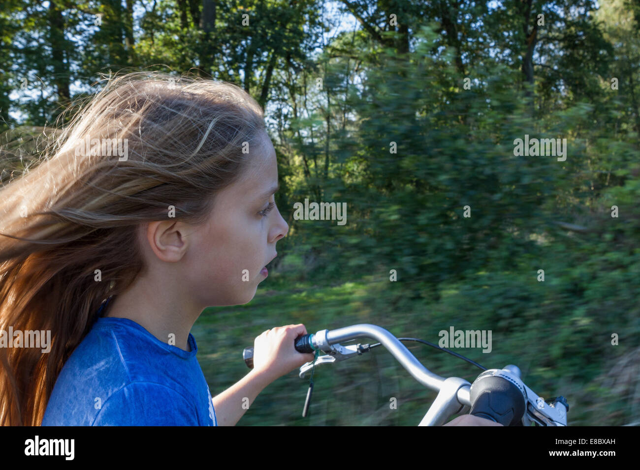 Ein junges Mädchen fährt Fahrrad durch die offene Landschaft mit Geschwindigkeit. -Modell veröffentlicht. Stockfoto