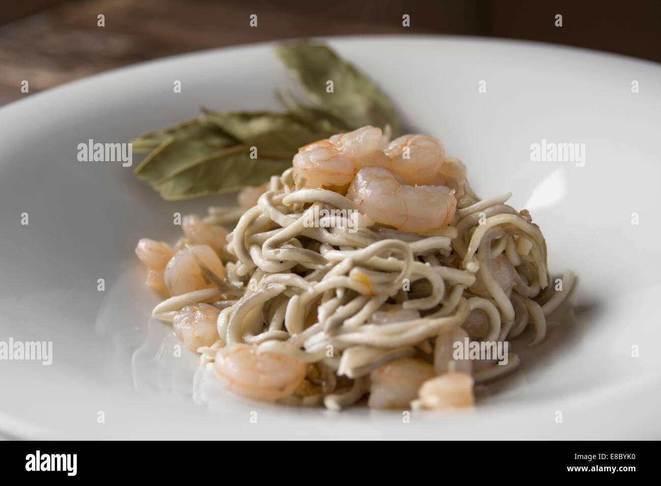 Gula oder Surimi, Gericht zubereitet mit Knoblauch und Olivenöl, sautierten Garnelen. Spanische gastronomischen Genuss, dunklem Holz. Hor Stockfoto