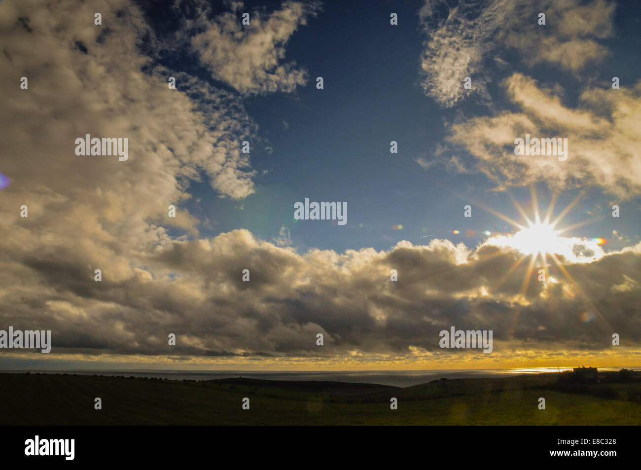 East Dean, East Sussex, UK. 4. Oktober 2014. Wetteränderung an der Südküste nach der späten Indian Summer. Wind und starkem Regenduschen mit der Sonne lugt durch die Wolken kurz vor Sonnenuntergang. Diese Aufnahme von der Hauptstraße zwischen Eastbourne und East Dean, Belle Tout Leuchtturm nur links von der Mitte. Bildnachweis: David Burr/Alamy Live-Nachrichten Stockfoto