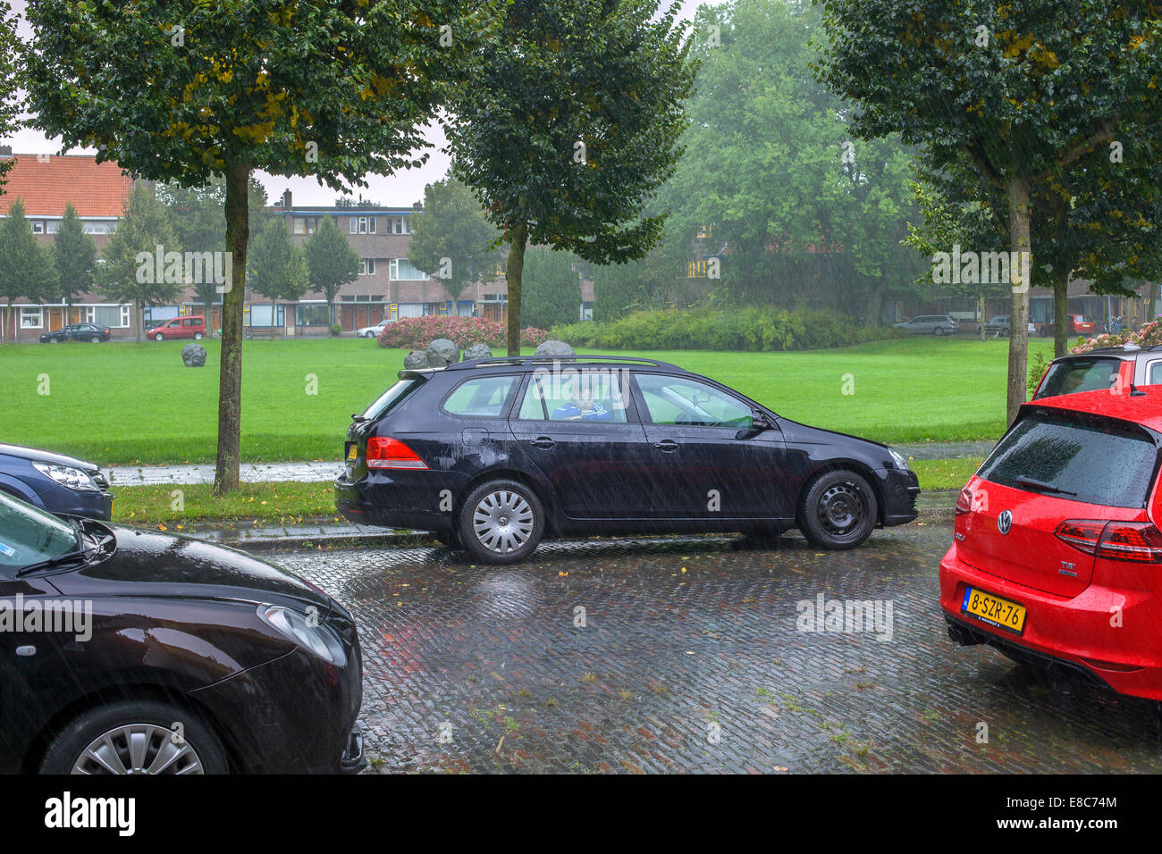 Junge in einem Auto im Regen auf einer Straße Stockfoto