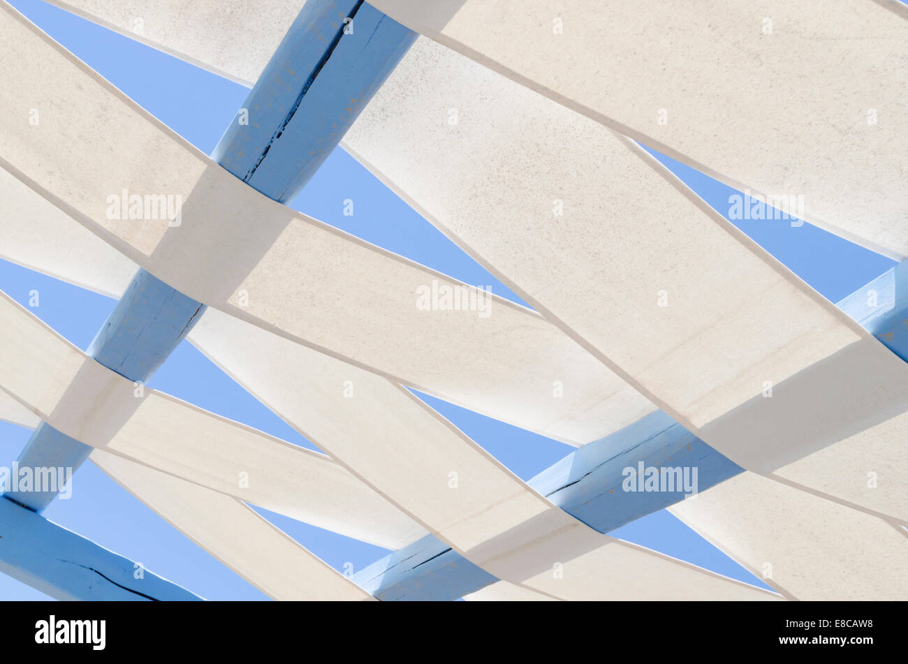 Sonnensegels durch gemalte blaue Holzbalken in Griechenland gewebt Stockfoto