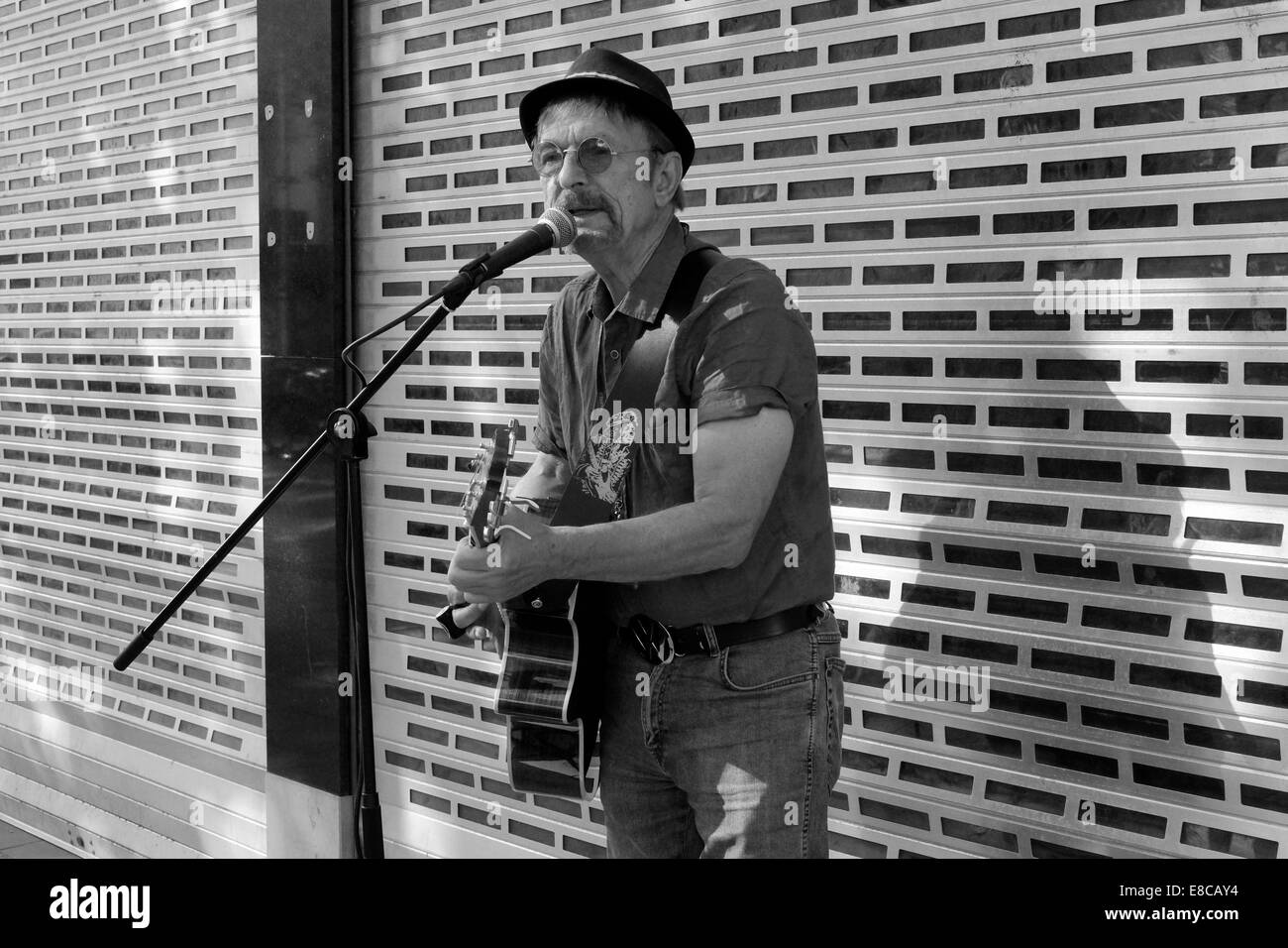 ältere männliche Busker mit Gitarre Gesang in einer Stadt Zentrum England uk Stockfoto