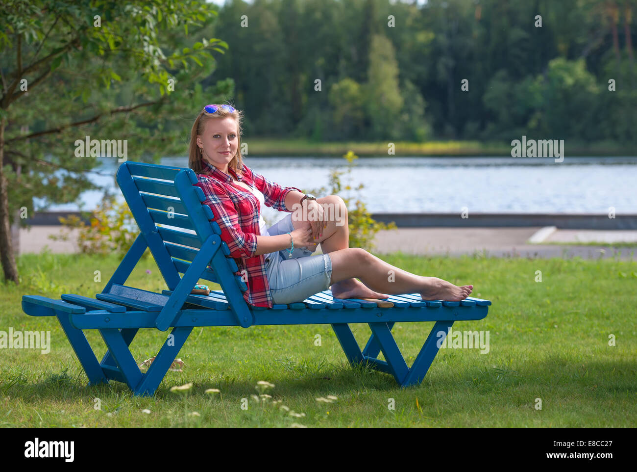 Junge schöne Frau, die Bräunung auf der Sonnenliege Stockfoto