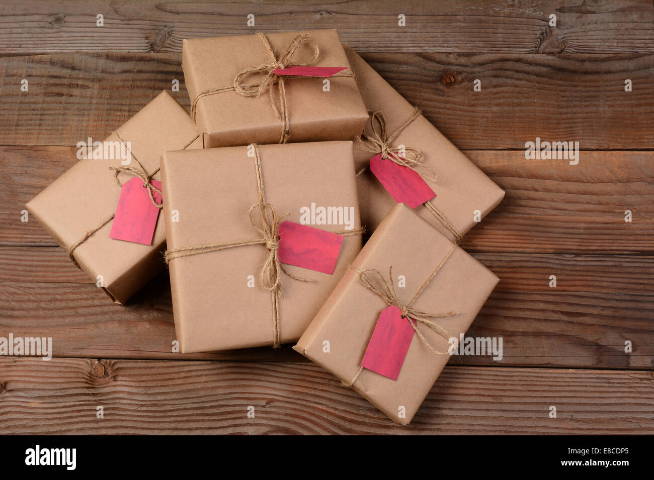 Ein Haufen von umweltfreundlich verpackt Weihnachtsgeschenke, auf einem rustikalen Holz Hintergrund. Stockfoto