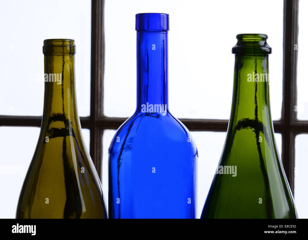 Leere Weinflasche Stillleben. Drei Flaschen Wein vor einem Fenster. Stockfoto