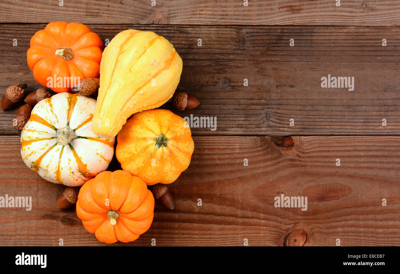 Ein Herbst Stilleben von dekorativen Mini Kürbisse, Kürbisse und Eicheln auf einem rustikalen Holztisch. Querformat mit Textfreiraum. Stockfoto