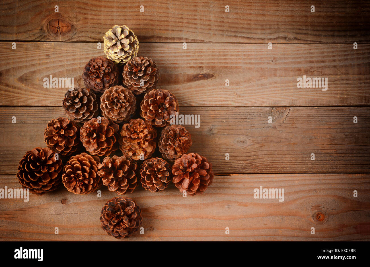 Eine Gruppe von Tannenzapfen in einen Weihnachtsbaum-Form auf einen rustikalen hölzernen Fußboden angeordnet, Horizontal format mit ein Instagram-retro-Look Stockfoto