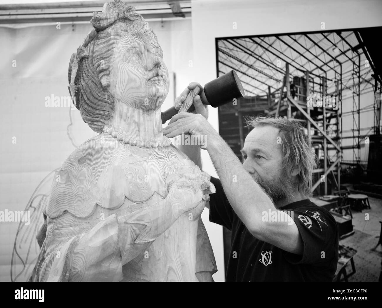 Ein Bildhauer eine hölzerne Statue einer traditionellen Frau schnitzen. Stockfoto