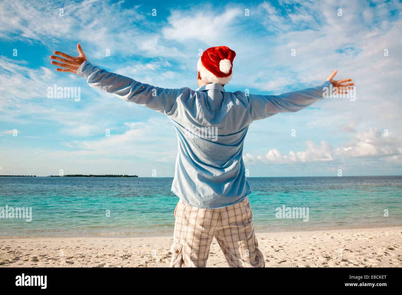 Weihnachtsferien - Mann in Nikolausmütze am tropischen Strand Stockfoto