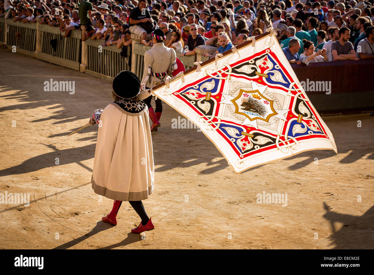 Mann trägt eine Flagge von Crested Stachelschwein Contrade, historischer Festzug vor das Pferderennen Palio di Siena, Siena, Italien Stockfoto