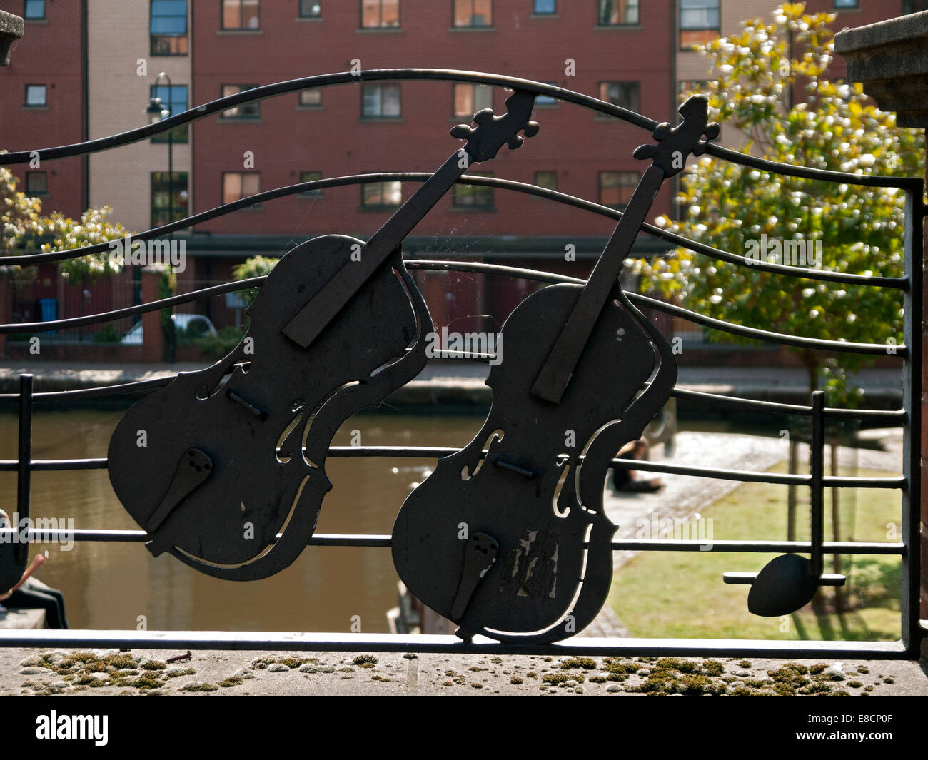 Musikinstrument, das unter dem Motto Metallgeländer auf eine Kanalbrücke in der Nähe von Bridgewater Hall, Manchester, England, UK Stockfoto