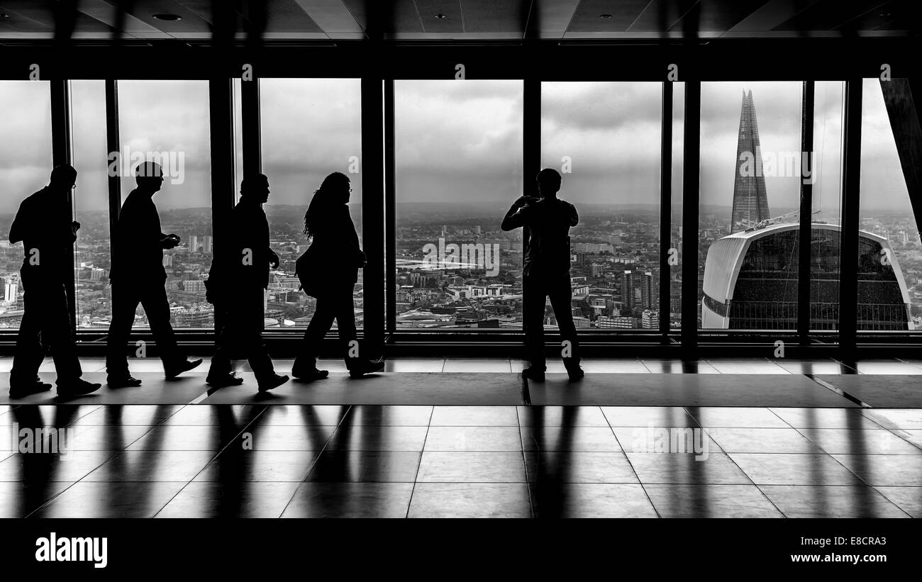 Silhouetten von Menschen auf der Suche aus einem Büro-Fenster in der City of London, das Walkie Talkie und die Scherbe Stockfoto