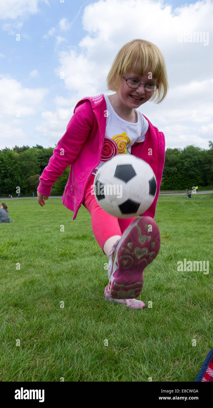 Junge Mädchen üben Fußball in einem öffentlichen park Stockfoto