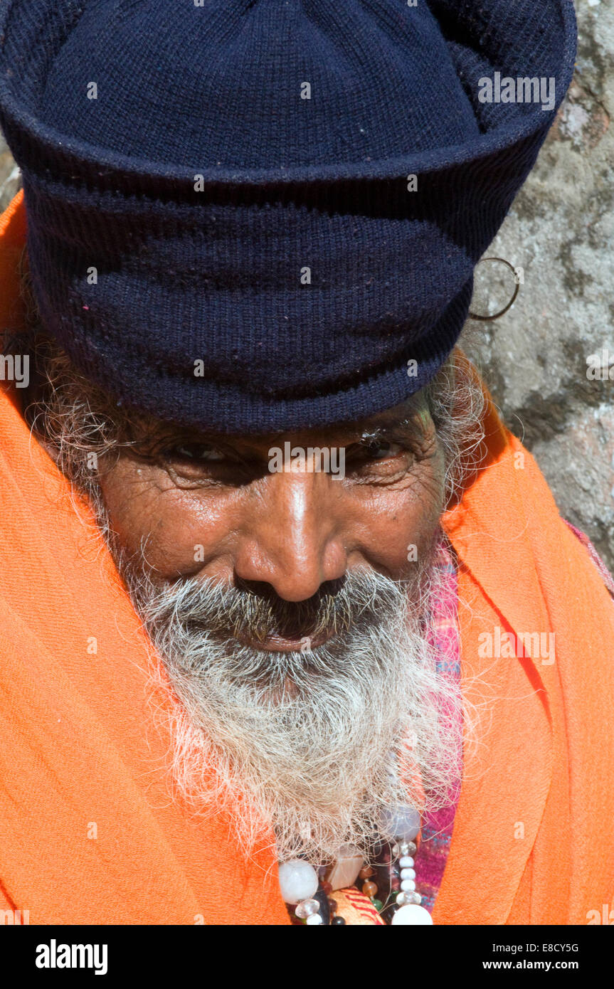 Elegante bärtigen Sadhu in Safran Roben, Silberperlen & unterschieden Hut von der sonnigen heiligen Fluss Ganges Rishikesh Uttarakanth Stockfoto