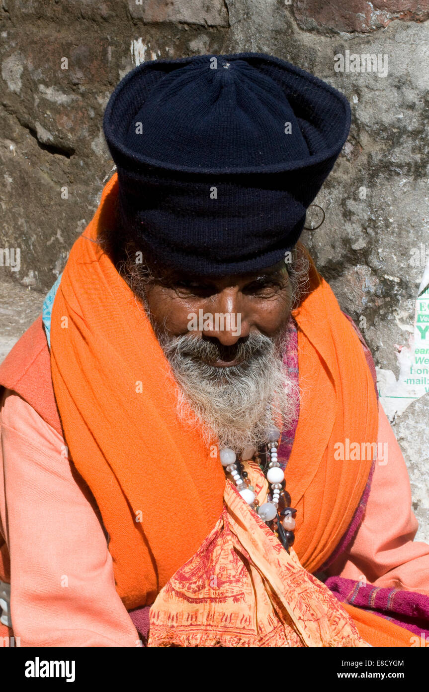 Elegante bärtigen Sadhu in Safran Roben, Silberperlen & unterschieden Hut von der sonnigen heiligen Fluss Ganges Rishikesh Uttarakanth Stockfoto