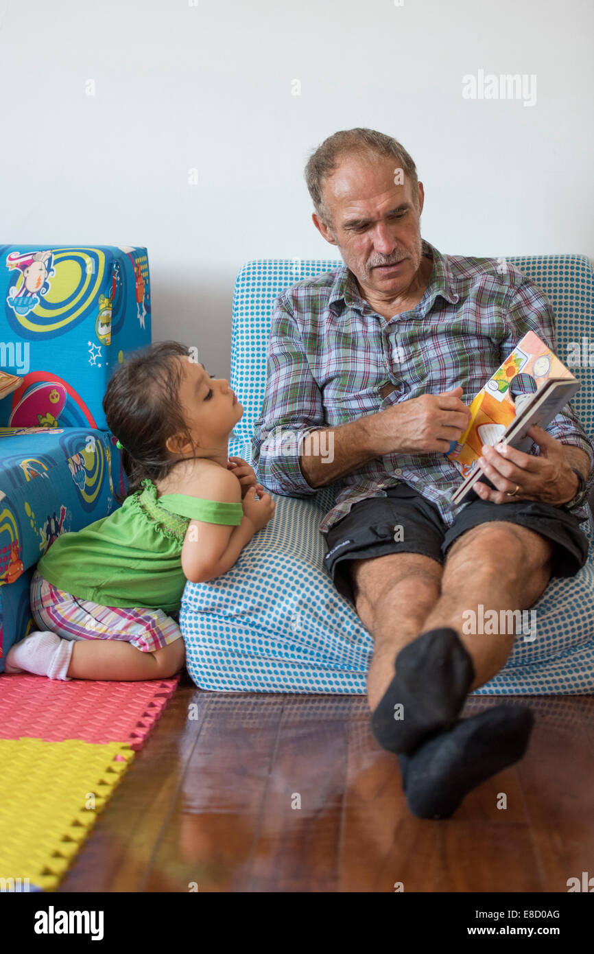 Großeltern, Enkel lesen Stockfoto