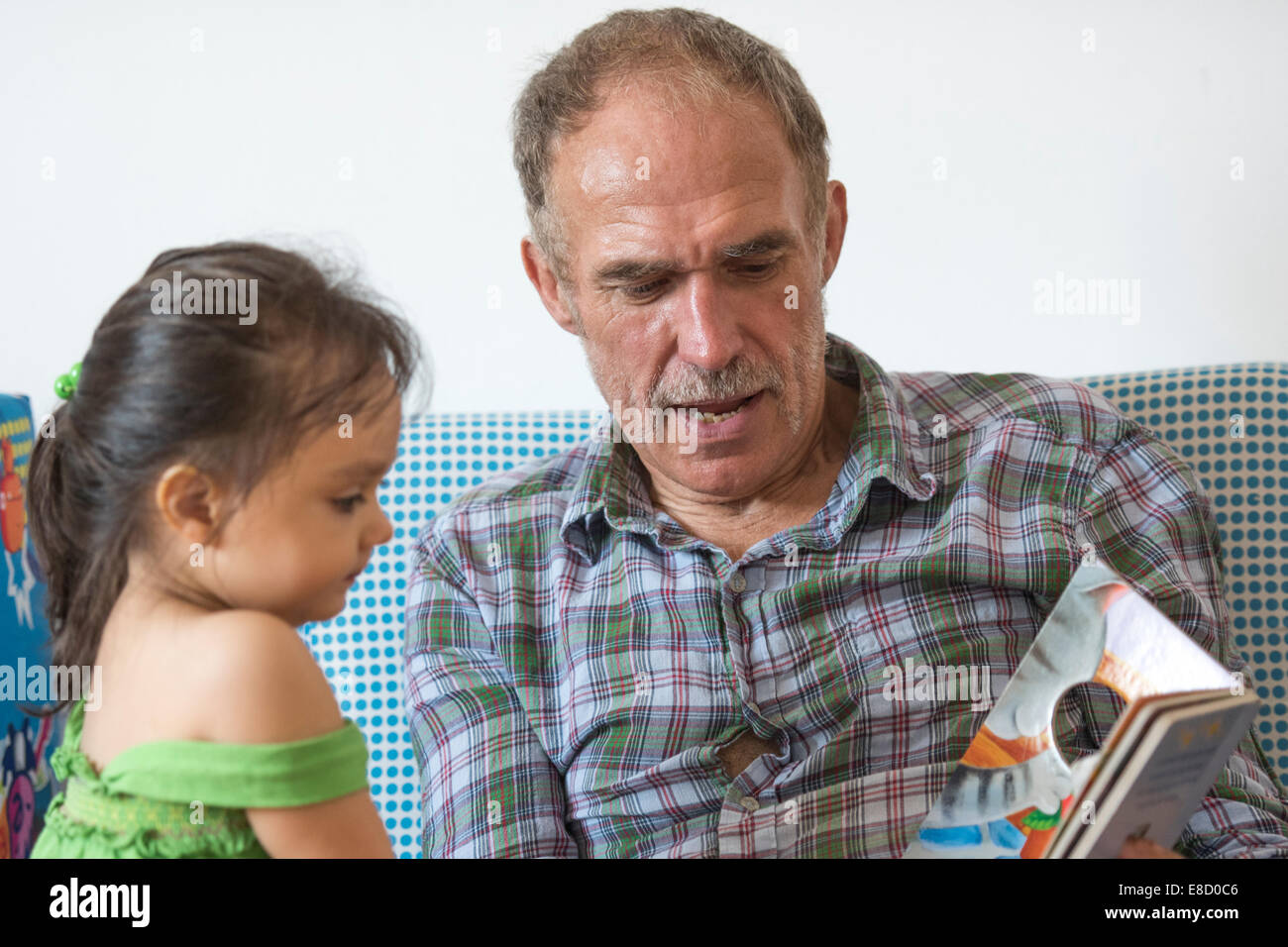 Großeltern, Enkel lesen Stockfoto