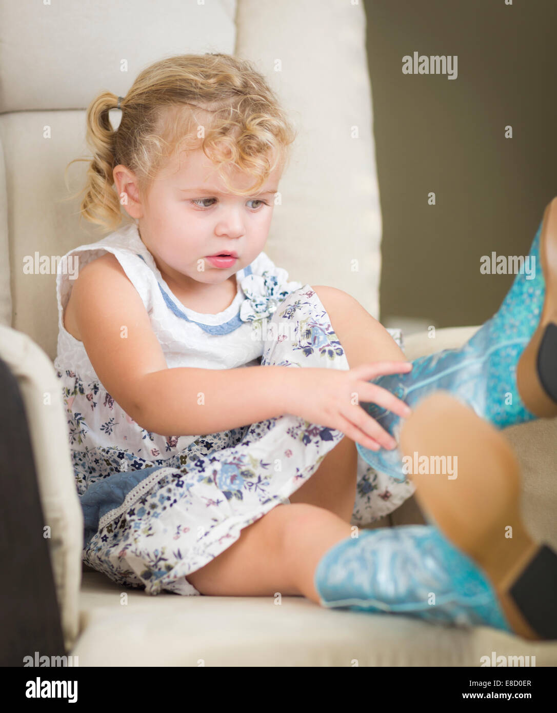 Entzückende Blonde behaarte Blue Eyed Mädchen Cowboy Stiefel anziehen. Stockfoto