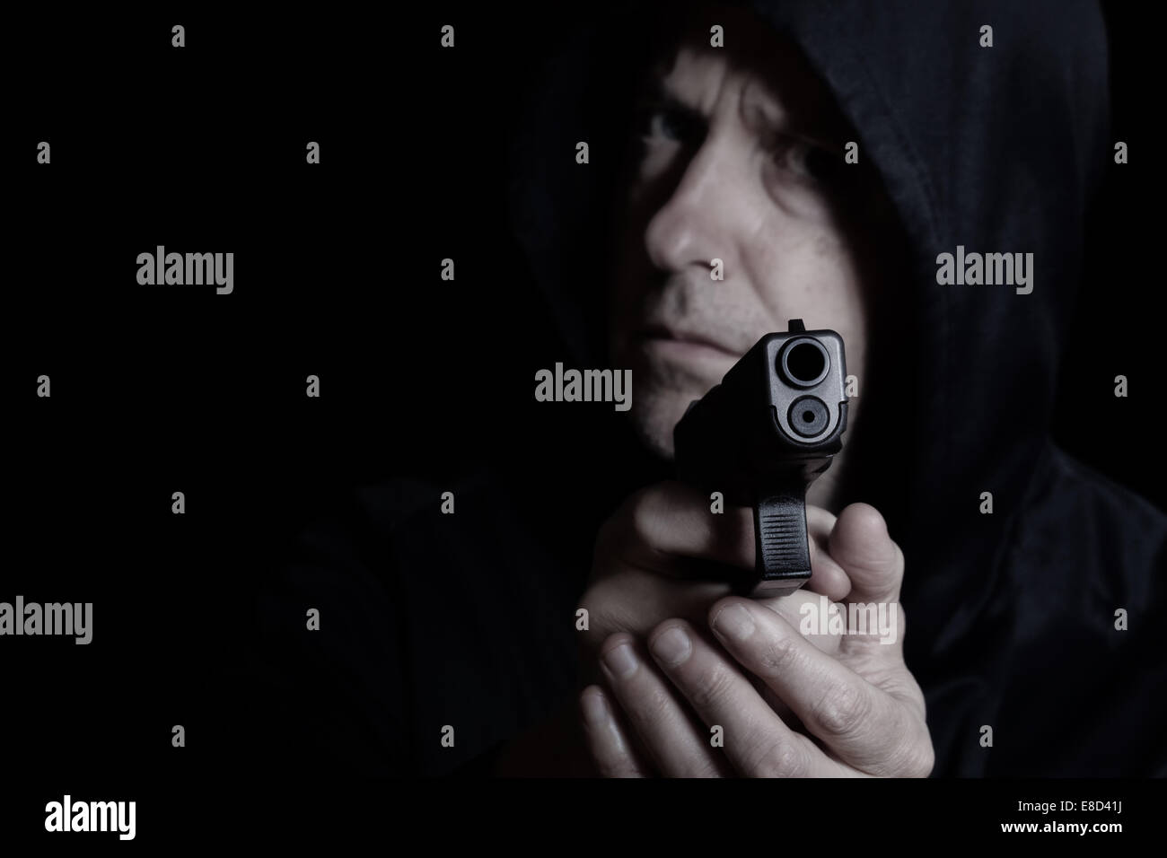 Closeup Vorderansicht der Pistole vor verzweifelten Mann im dunklen Hintergrund Stockfoto