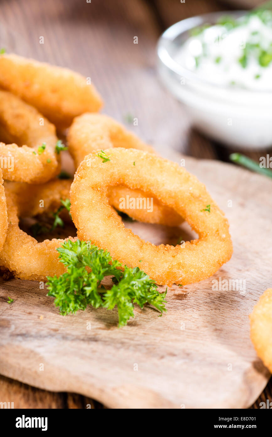 Portion hausgemachte Zwiebelringe mit frischen Kräutern Stockfoto