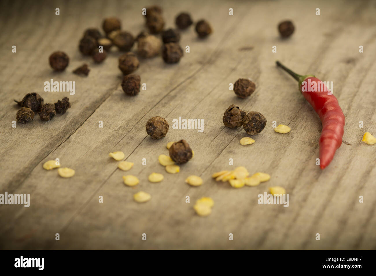 Rote scharfe Chilischoten mit Gewürz-Zutaten über hölzerne Hintergrund Stockfoto