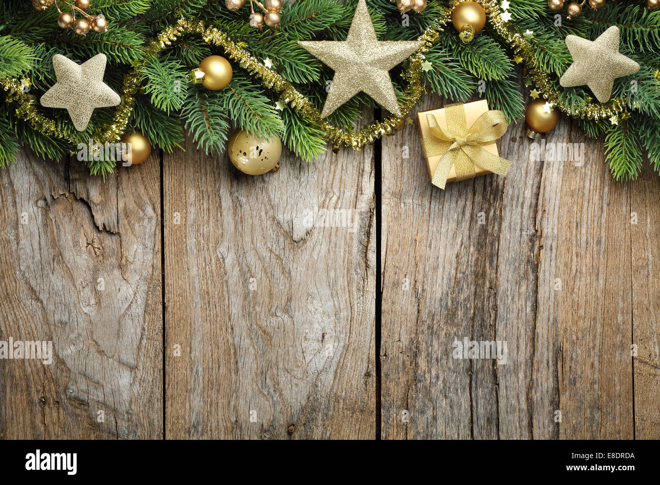 Tanne Zweig mit goldenen Geschenkbox, Kugeln und Sterne auf hölzernen Hintergrund Stockfoto