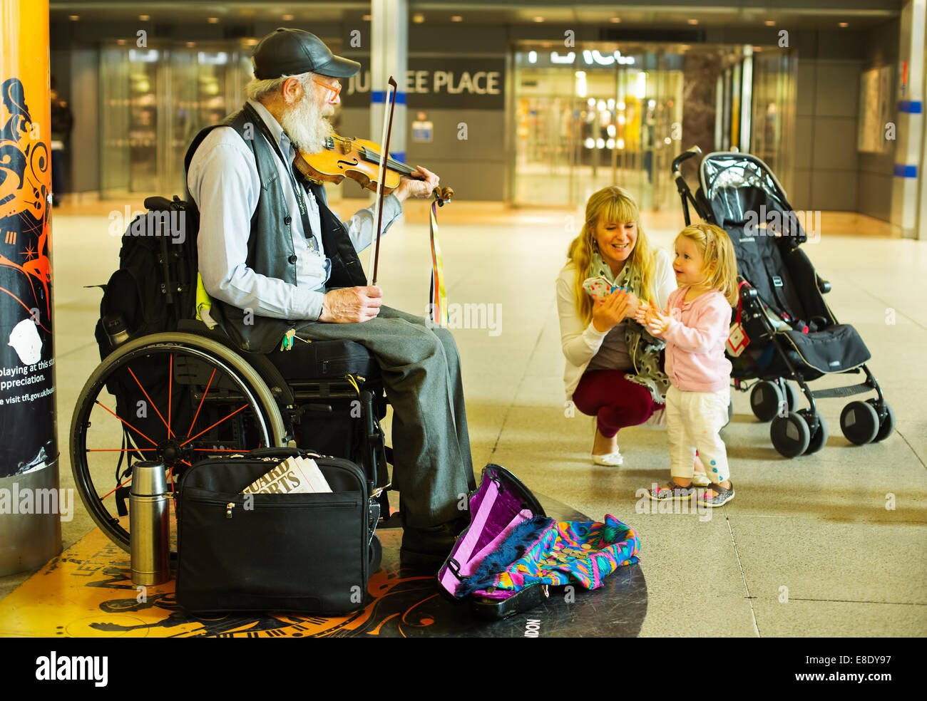 Eine alte Straßenmusikant das Geigenspiel am Bahnhof London Stockfoto