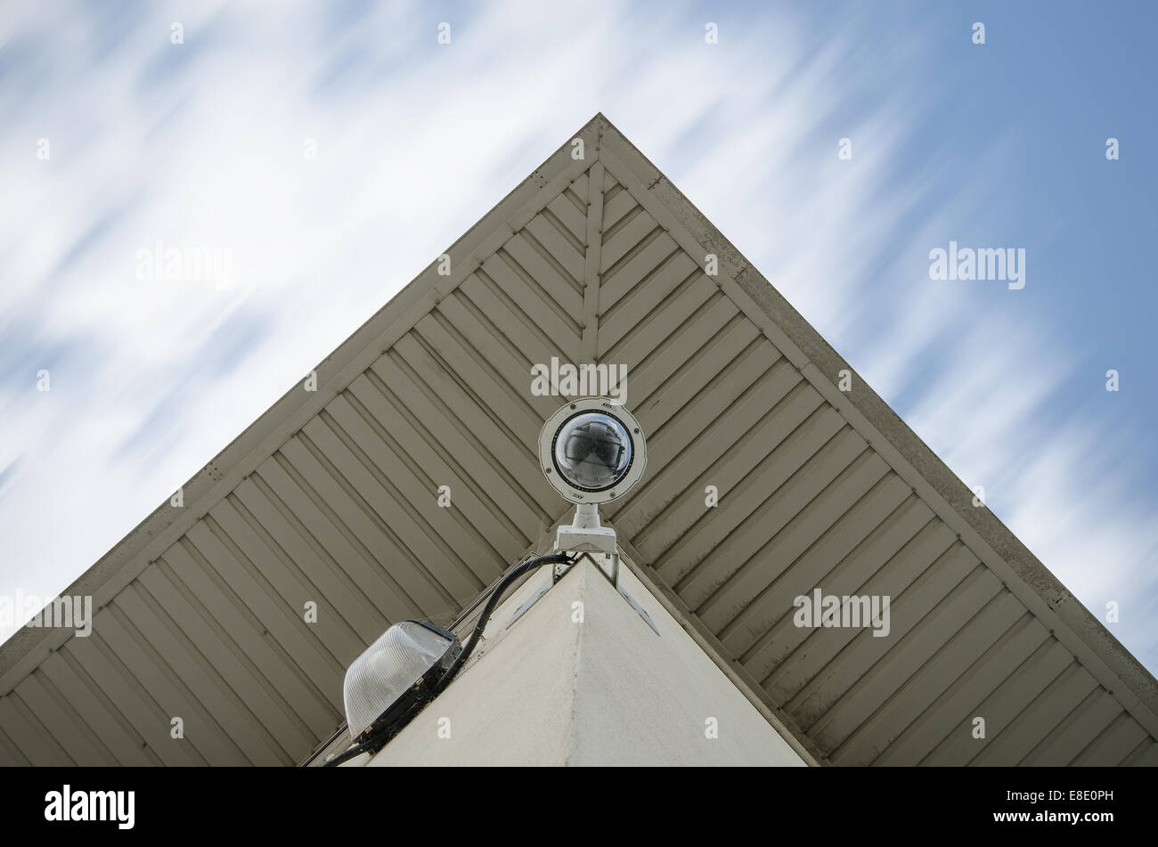 Überwachung mit kontrollierten Fernkamera auf der Ecke des Gebäude-Architektur mit reflektierenden Himmel im Fenster verschieben Wolke Stockfoto