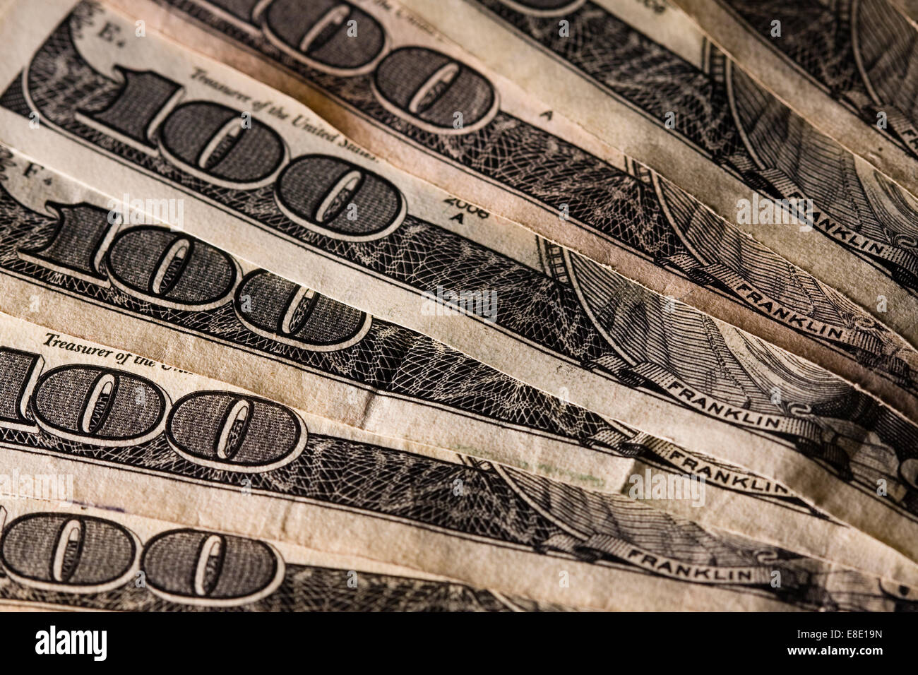 Viele hundert-Dollar-Scheine aufgefächert auf eine Tischplatte Stockfoto