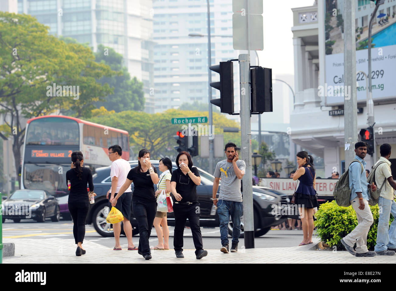 (141006)--Singapur, 6. Oktober 2014 (Xinhua)--Fußgänger decken ihre Münder in Singapur, 6. Oktober 2014. Singapurs 3-stündigen Verschmutzung Standard Index (PSI) hit 147 am Montag. (Xinhua/Then Chih Wey) Stockfoto