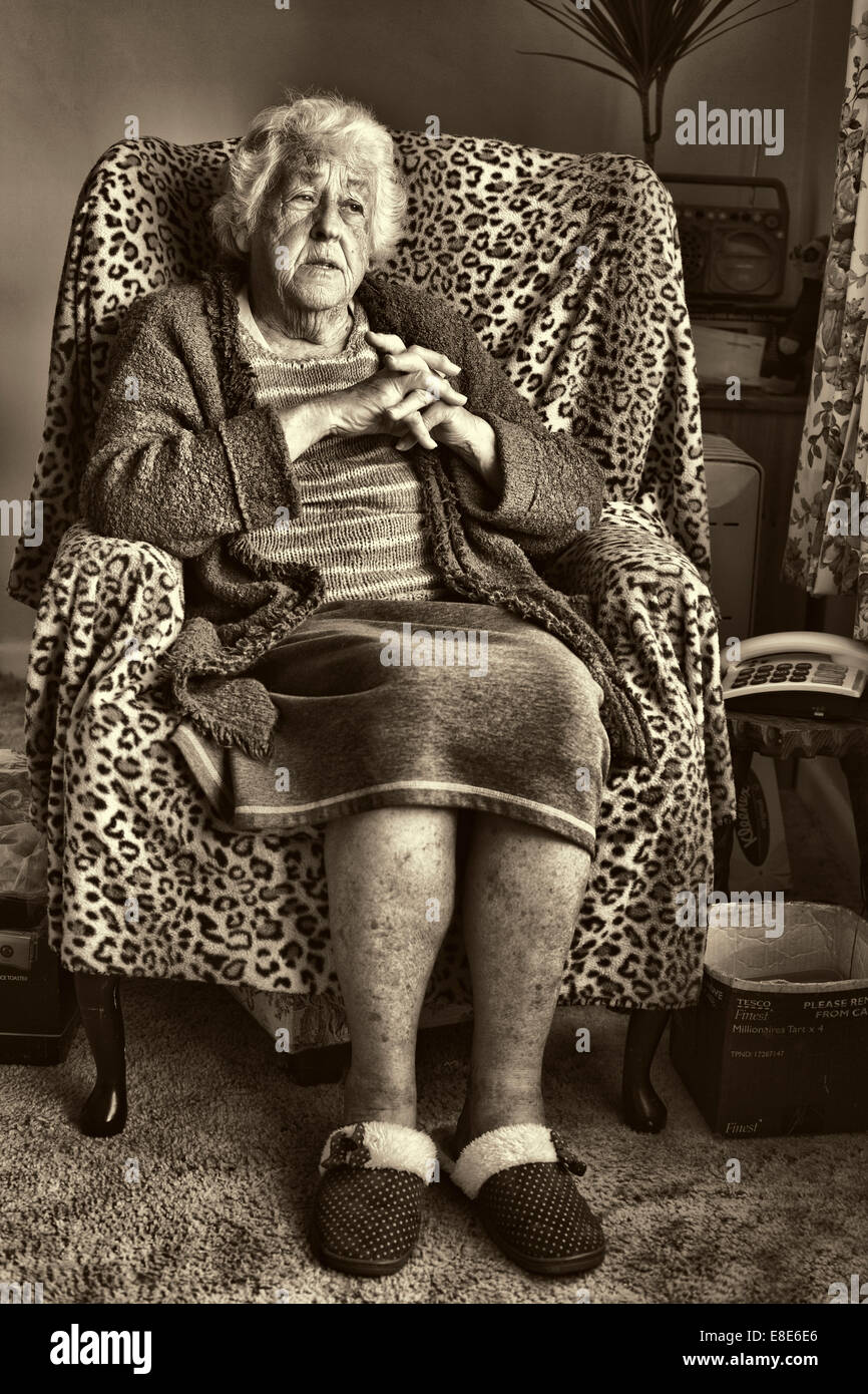 Eine ältere Dame saß in ihrem Stuhl Erinnerungen. Stockfoto