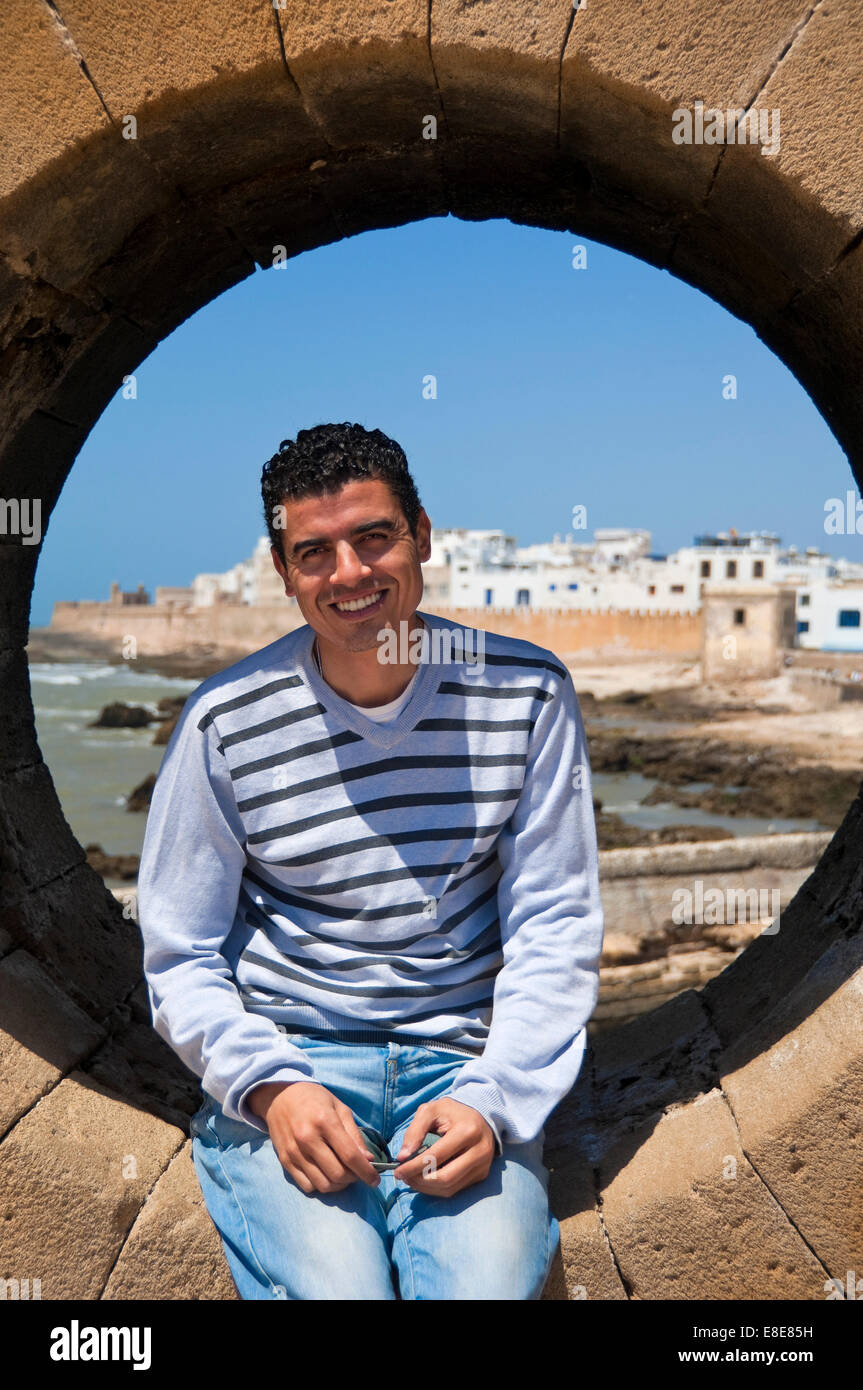 Vertikale Porträt eines lokalen marokkanischen Menschen sitzen in einem Bullauge auf der Skala in Essaouira Stockfoto
