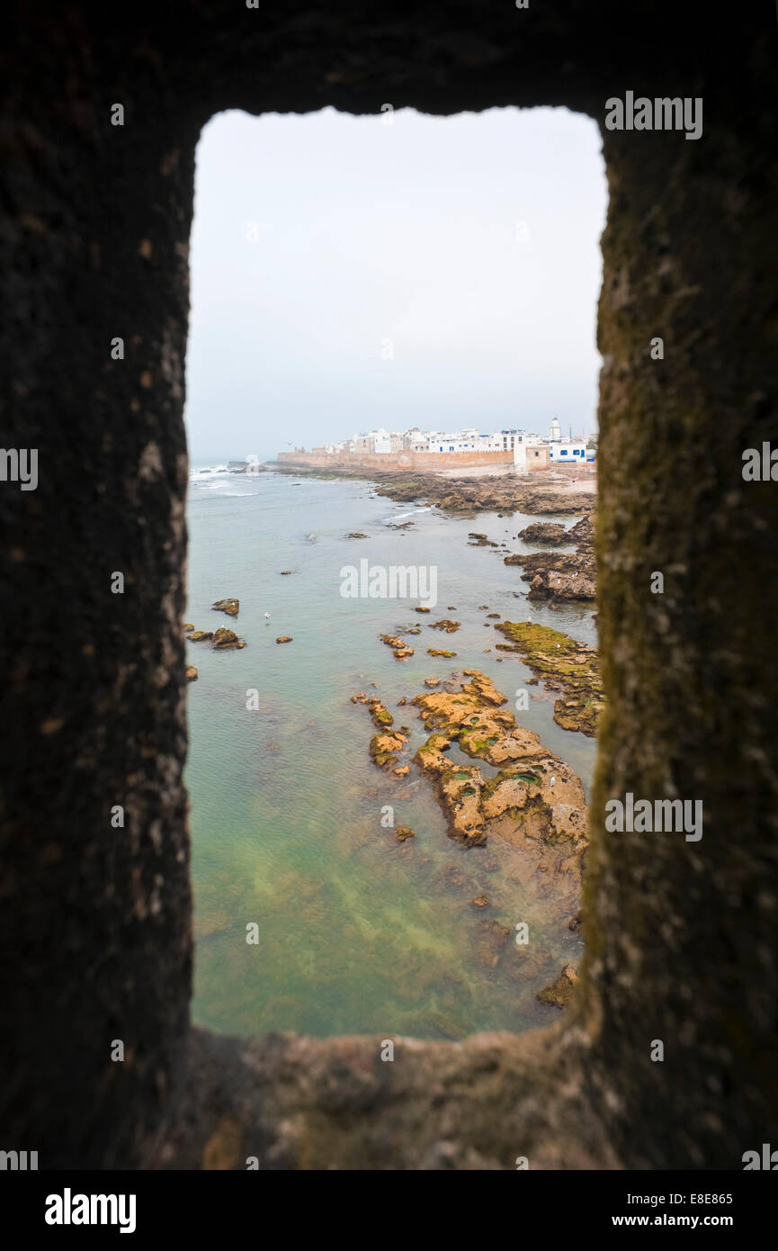 Vertikale Ansicht von Essaouira durch ein Quadrat Bullauge des Hafens Stadtmauer. Stockfoto