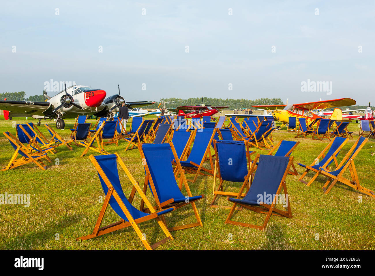 Blaue Liegestühlen verteilt am Goodwood Revival 2014 Flugplatz, West Sussex, Großbritannien Stockfoto