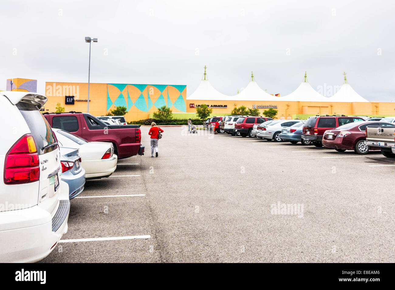 Das Outlet Shoppes in Oklahoma City Shopper und die Mall vom Parkplatz in Oklahoma City, Oklahoma, USA zeigen. Stockfoto