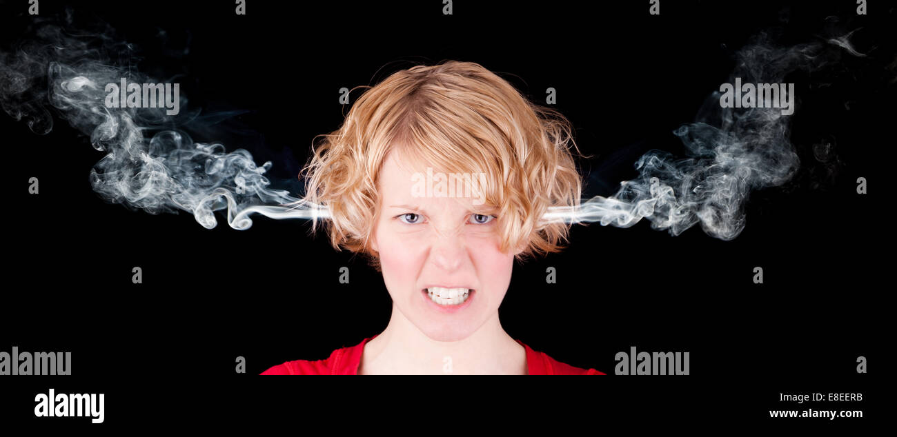 Sehr böse Frau mit Rauch auf schwarzem Hintergrund isoliert Stockfoto