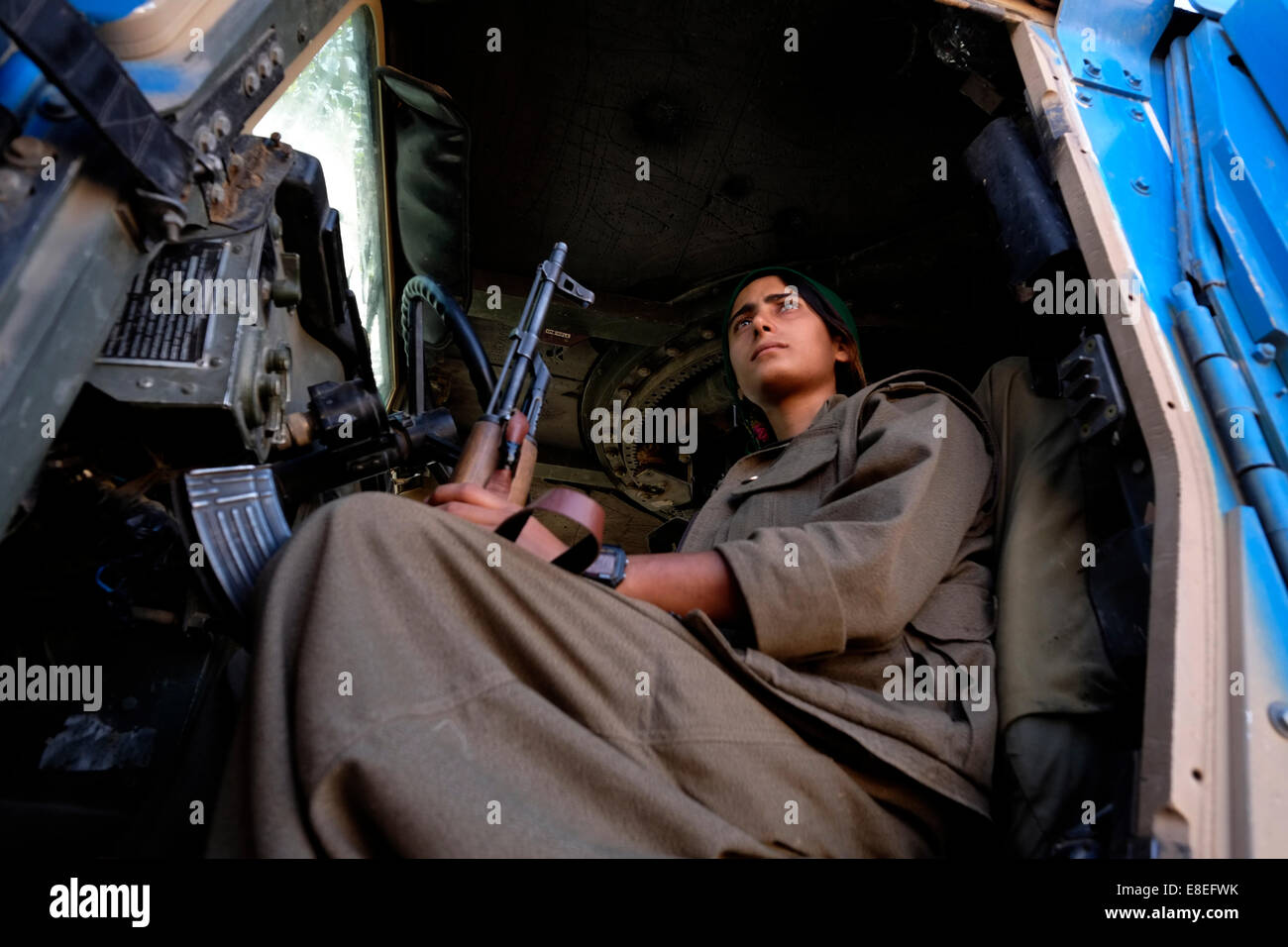 Iranische geboren Rozhin Zhan kurdischen Weibliche Kämpfer der kurdischen Arbeiterpartei PKK oder standortwahl mit einer Kalaschnikow AK-47 Gewehr in einem gepanzerten Fahrzeug in der Nähe der Stadt Kirkuk im Nordirak Stockfoto