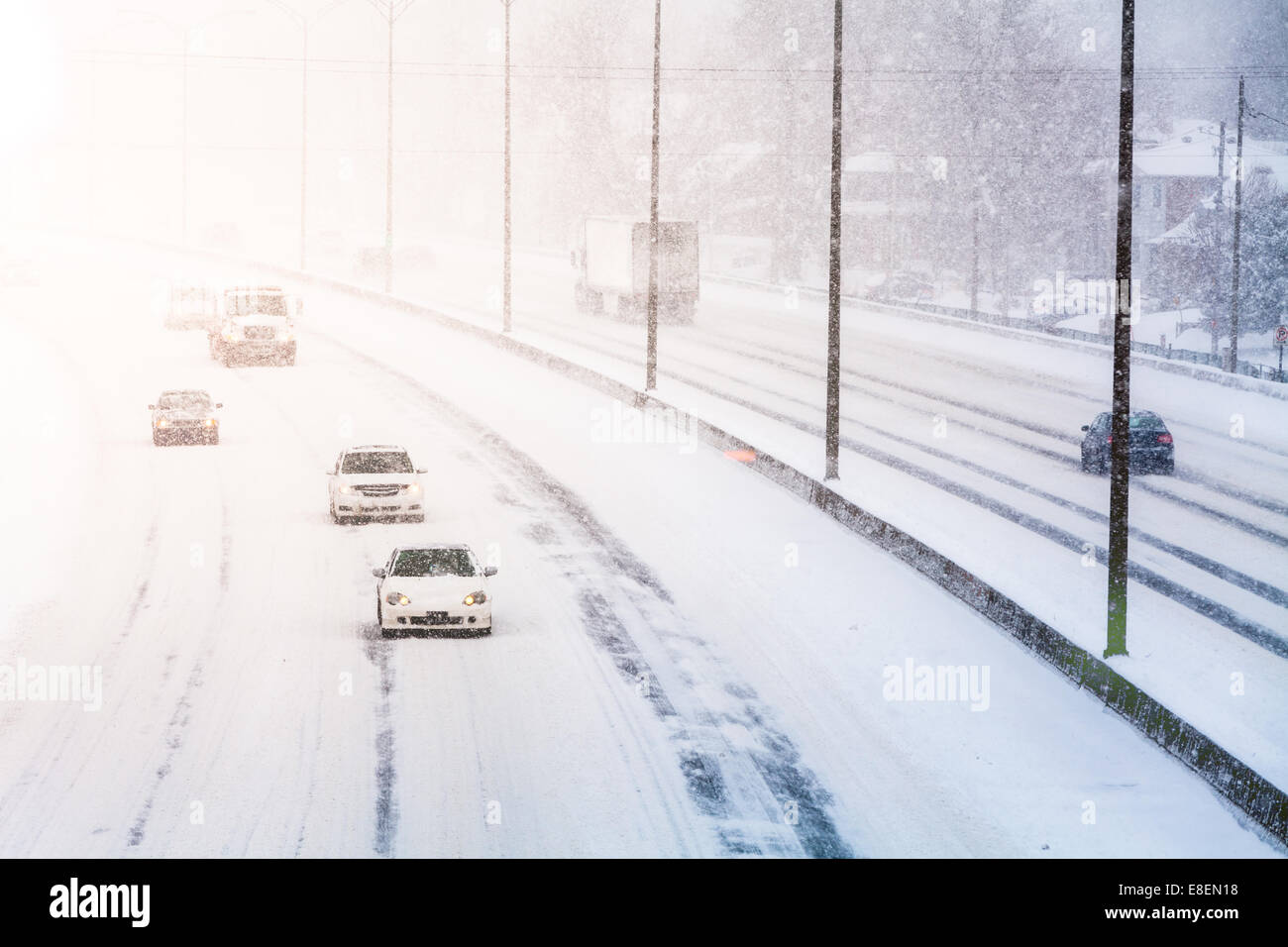 Störenden Sonnenuntergang Licht und Schneesturm auf der Autobahn aufgrund der schlechten Sichtbarkeit Stockfoto