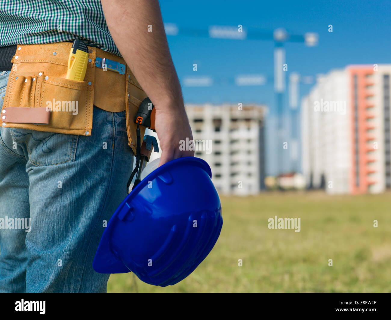 Nahaufnahme des männlichen Ingenieur mit blauen Bauarbeiterhelm, mit Bauten im Bau auf Hintergrund Stockfoto