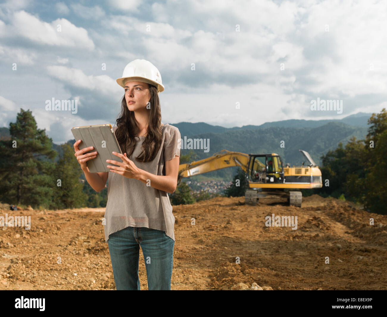 Porträt des jungen kaukasischen Ingenieurin auf Baustelle stehen, halten digital-Tablette, wegschauen Stockfoto