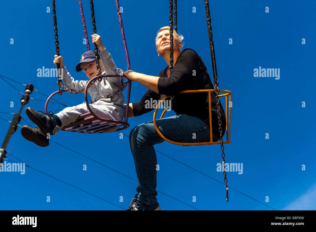 Aktives Altern, Leute an der Kette schaukeln Karussell, eine ältere Frau mit einem Enkel, Spaß Stockfoto