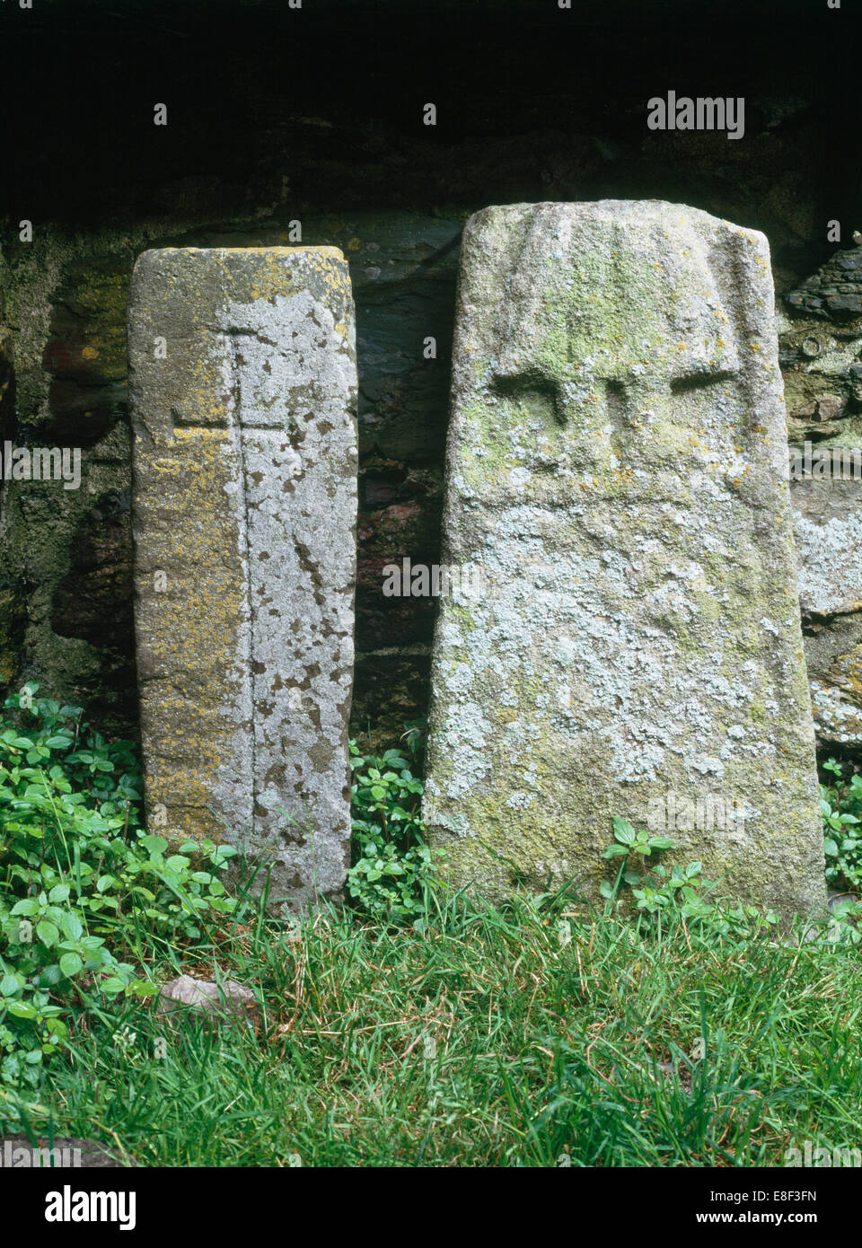 Str. Marys Abbey, Bardsey Island: Kreuz-geschnitzte Säule Grab Marker & Kreuz-Welle Fragment mit Unterteil der Figur trägt ein Plissee Kleid. Stockfoto