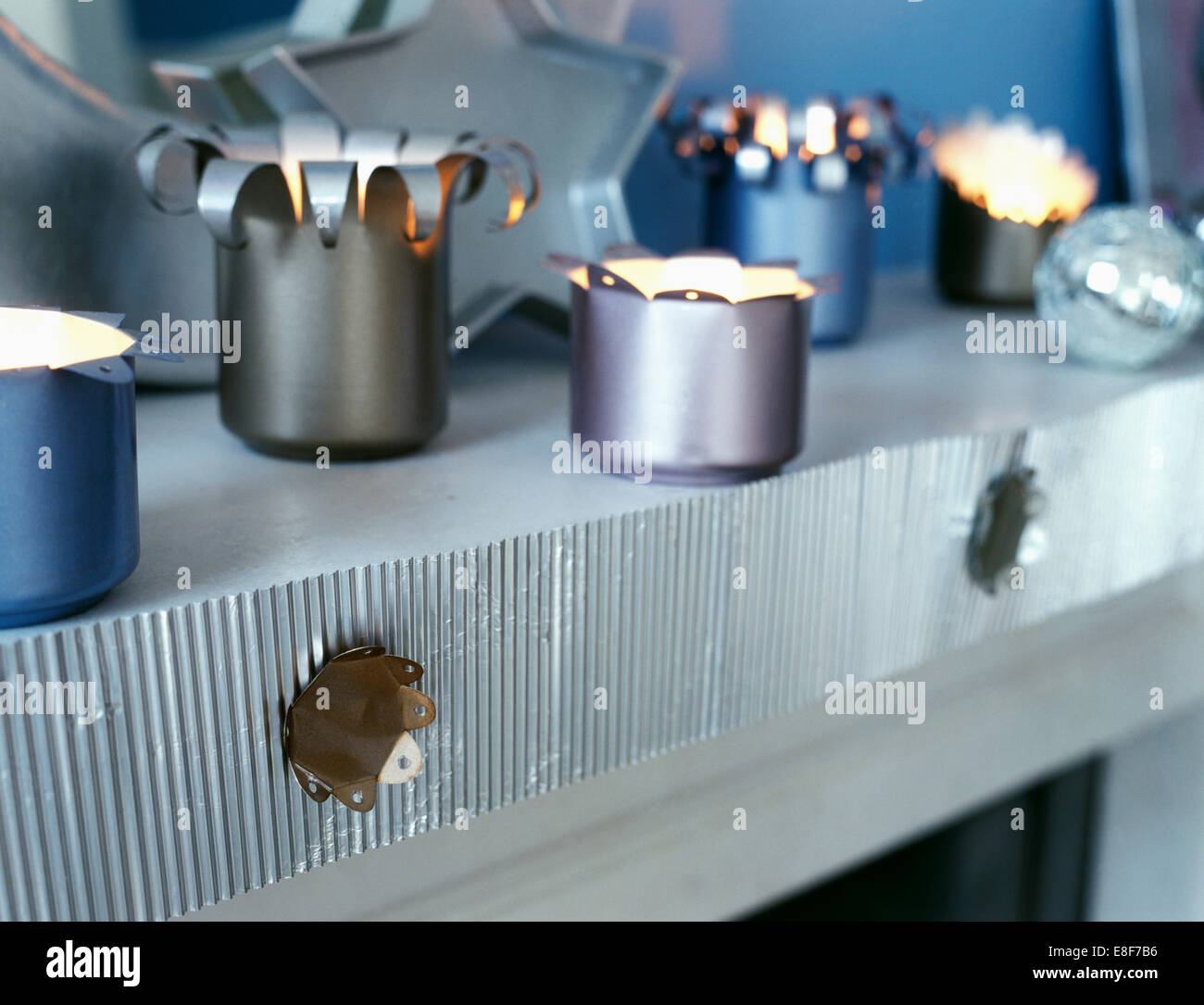 Nahaufnahme des brennenden Teelichtern in Kerzenhalter gemacht aus alten Dosen auf Regal mit Silber Wellpappe trim Stockfoto Nahaufnahme des brennenden Teelichtern in Kerzenhalter gemacht aus alten Dosen auf Regal mit Silber Wellpappe trim Stockfoto