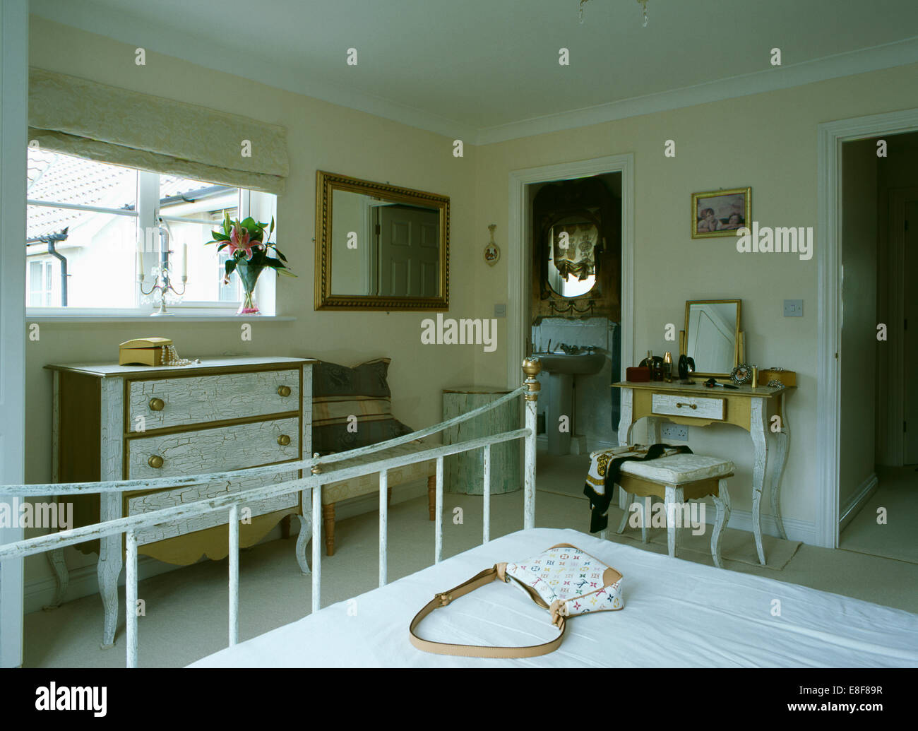 Handtasche auf alten lackiertem Messingbett in traditionellen Schlafzimmer mit Tür öffnen, En-Suite Badezimmer Stockfoto