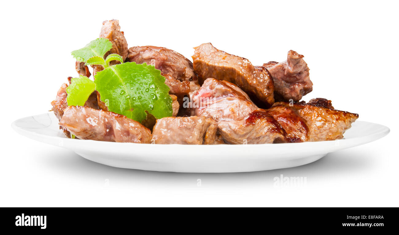 Gegrilltes Fleisch auf einem weißen Teller gedreht mit Minze, Isolated On White Background Stockfoto