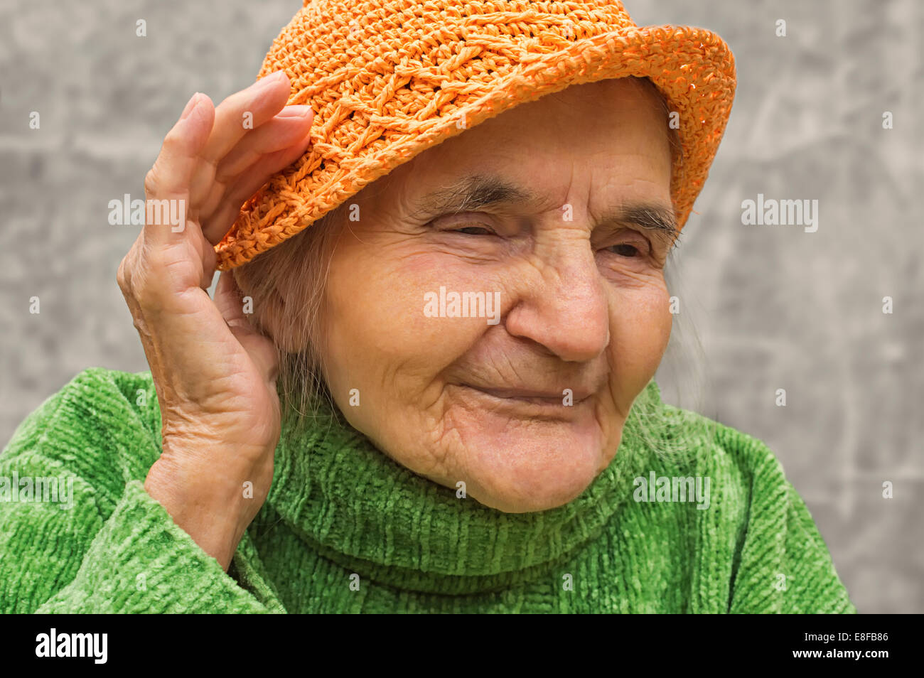 Ältere Frau mit Hand in der Nähe des Ohres. Hörprobleme. Stockfoto