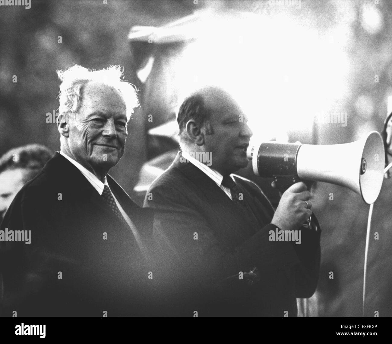 Der ehemalige deutsche Bundeskanzler Willy Brandt (L) lächelt während Berlins Bürgermeister Walter Momper (beide SPD, SPD) befasst sich mit die Massen während die Hauptkundgebung einen Tag nach dem Fall der Mauer außerhalb Schöneberger Rathaus, West Berlin, 10. November 1989. Am 9. November 1989 musste die DDR-Führung die Grenze im Westen aufgrund der anhaltenden Massenproteste zu öffnen. Stockfoto